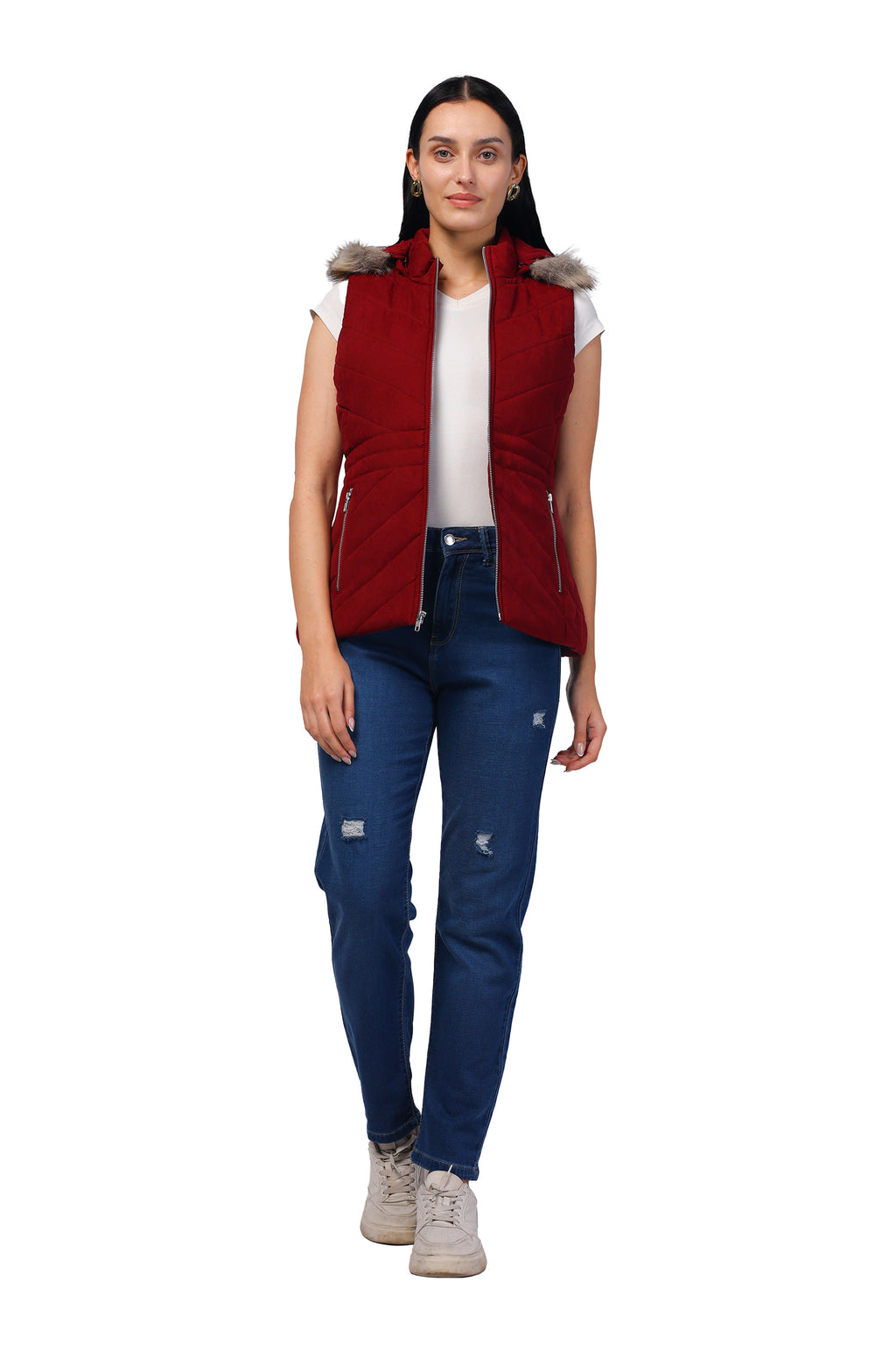 A woman modeling a sleeveless burgundy puffer vest with a faux-fur trimmed hood, worn over a white t-shirt and blue jeans, against a plain white background.