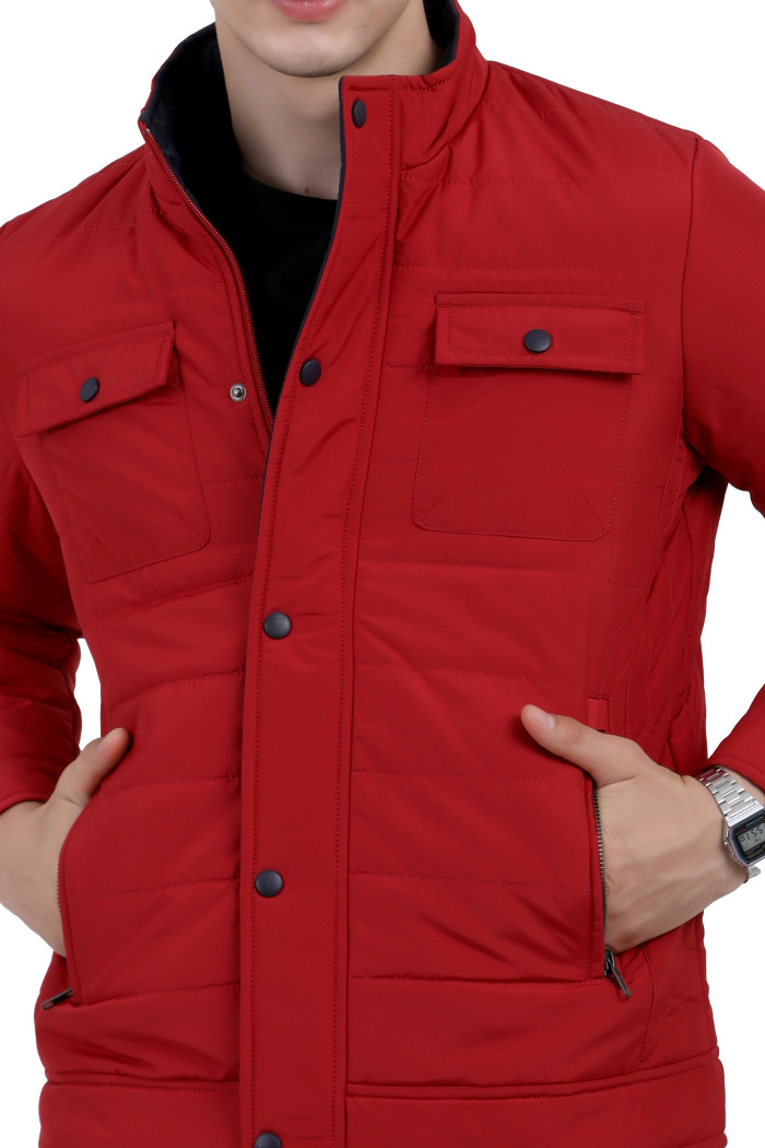 A cropped image of a man wearing a Red quilted jacket with a high neck collar, zipper closure and pocket in hand designed for casual winter layering and comfort.