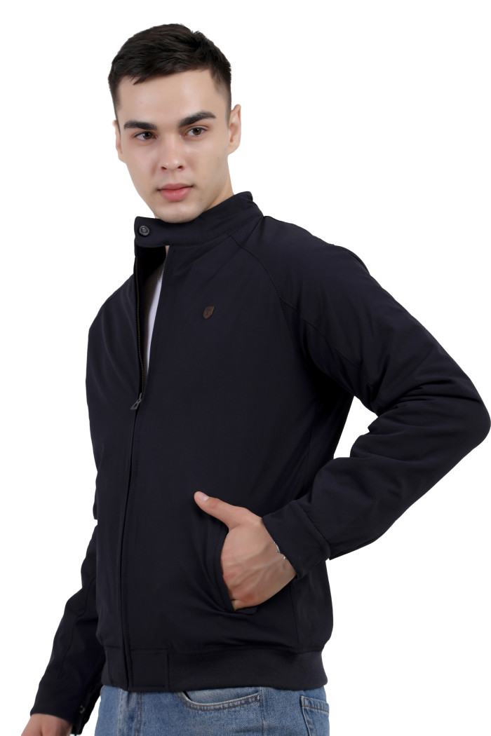 A left pose of a man wearing a Navy quilted jacket with a high neck collar, zipper closure and pocket in hand designed for casual winter layering and comfort.