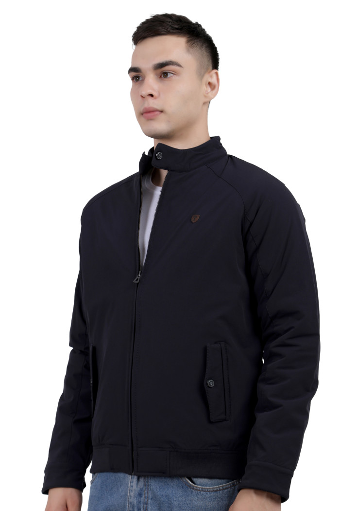 A man wearing a Navy quilted jacket with a high neck collar, zipper closure and pocket in hand designed for casual winter layering and comfort.