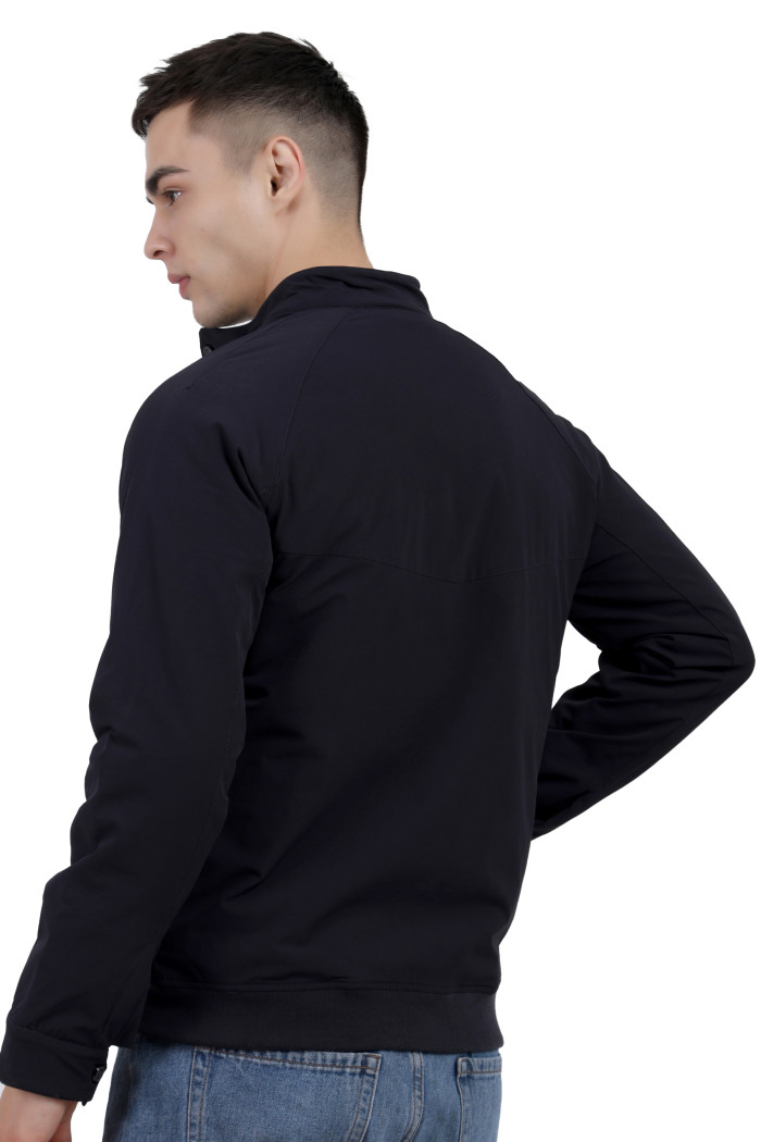 A back pose of a man wearing a Navy quilted jacket with a high neck collar, zipper closure and pocket in hand designed for casual winter layering and comfort.