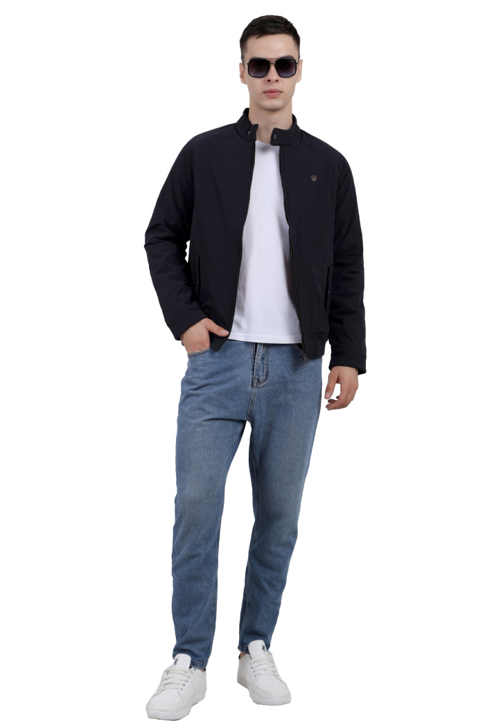 A tilted pose of a man wearing a Navy quilted jacket with a high neck collar, zipper closure and pocket in hand designed for casual winter layering and comfor