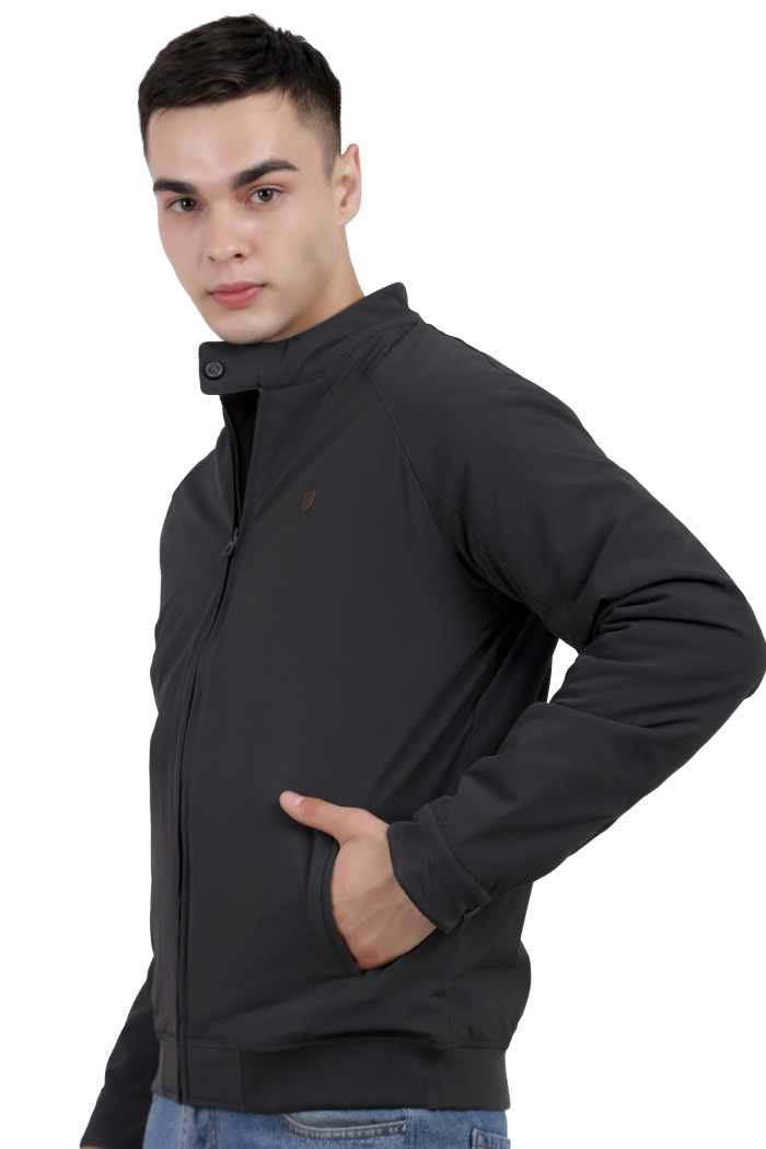 A left pose of a man wearing an olive quilted jacket with a high neck collar, zipper closure and pocket in hand designed for casual winter layering and comfort.