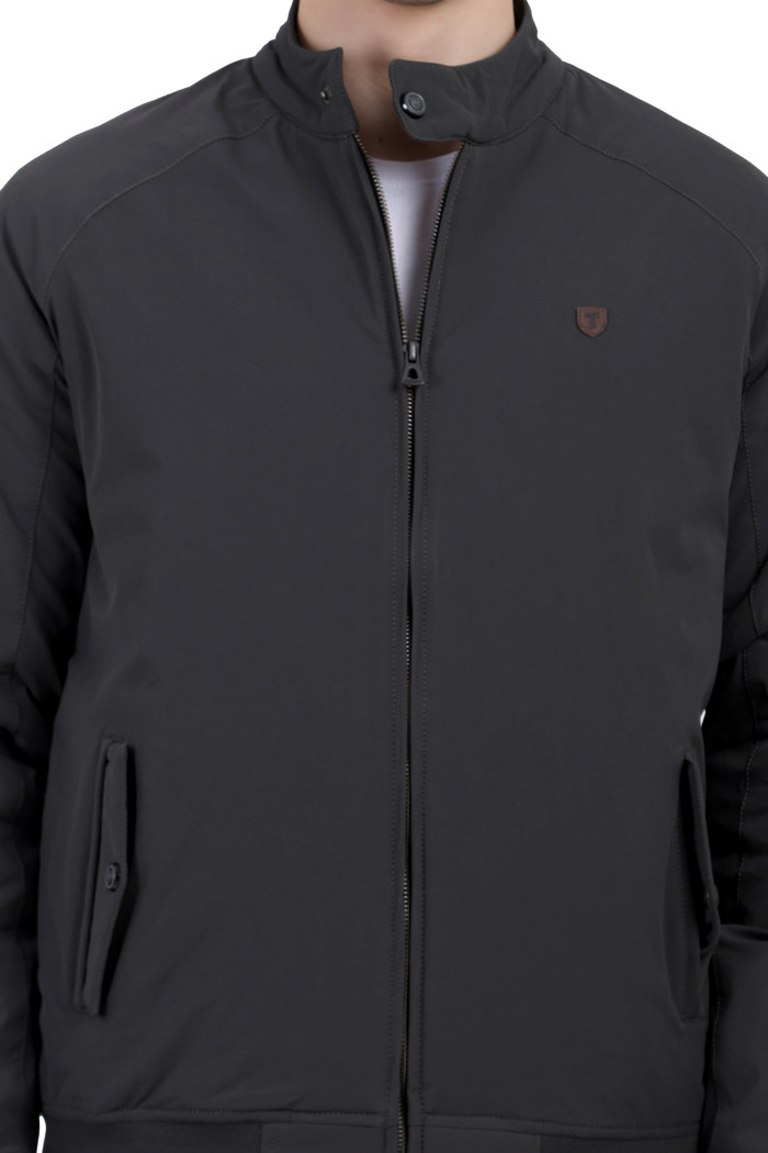 A cropped image of a man wearing an olive quilted jacket with a high neck collar, zipper closure and pocket in hand designed for casual winter layering and comfort.