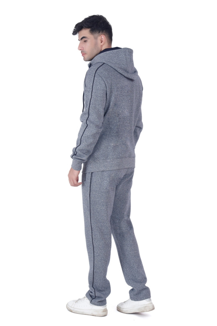 A man in a Coatsmore’s navy hooded tracksuit with black piping, shown from the back while turning his head slightly to the side, wearing white sneakers and standing against a white background.