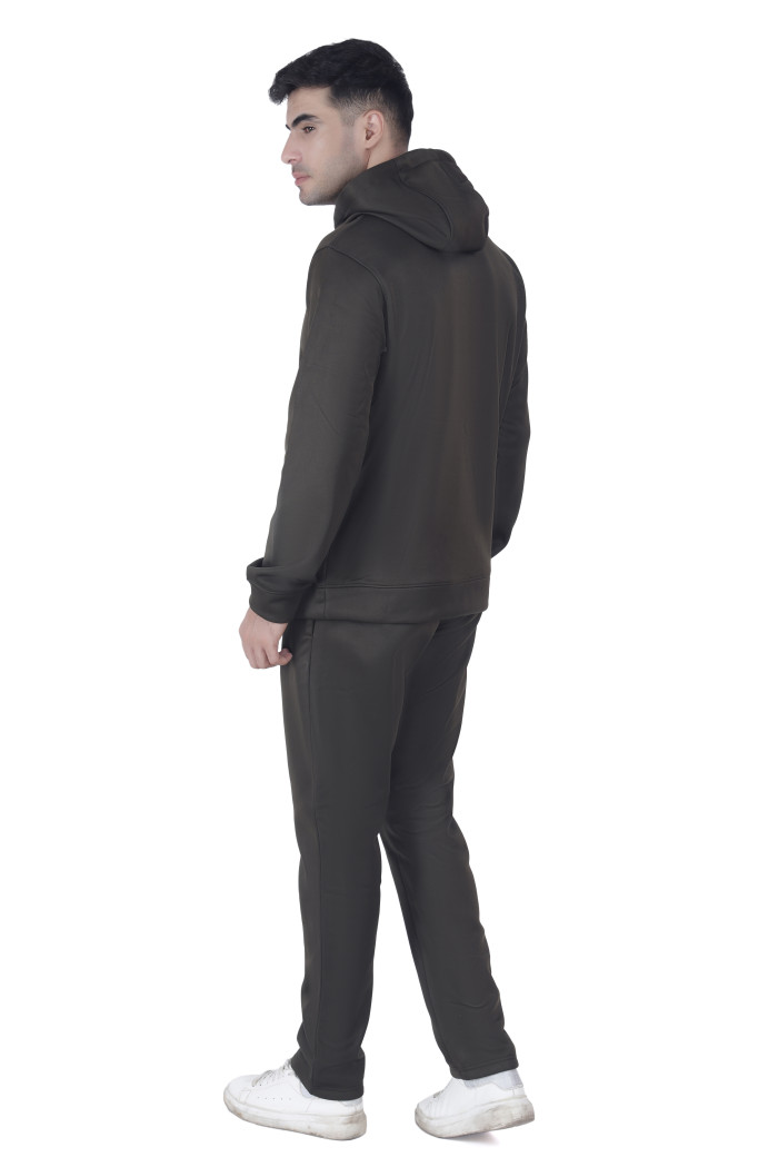 A man in Coatsnmore’s olive hooded tracksuit, shown from the back while turning his head slightly to the side, wearing white sneakers against a white background.