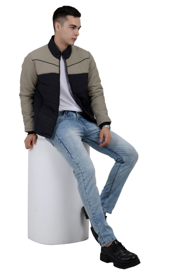 A tilted pose of a man wearing a Black-Camel dual Tone Quilted Jacket with mock collar, zipper closure and pocket in hand designed for casual winter layering and comfort.