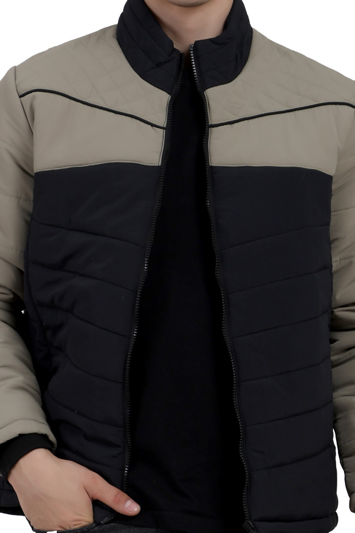 A cropped image of a man wearing a Black-Camel dual Tone Quilted Jacket with mock collar, zipper closure, and pocket in hand designed for casual winter layering and comfort.