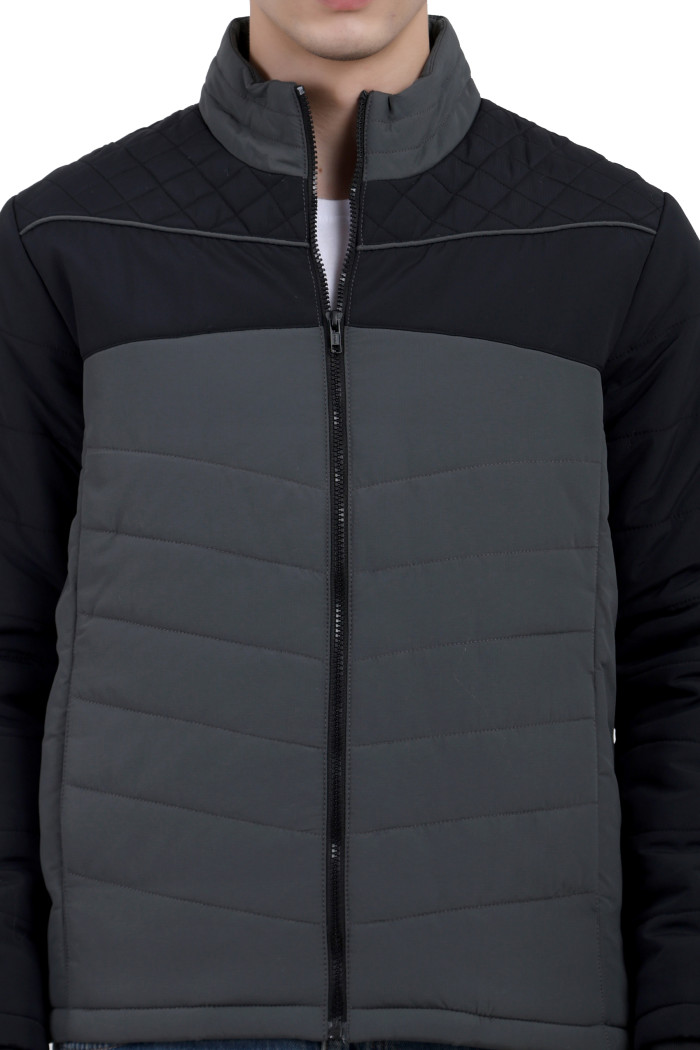 A cropped image of a man wearing a Black-Grey dual Tone Quilted Jacket with mock collar, zipper closure, and pocket in hand designed for casual winter layering and comfort.