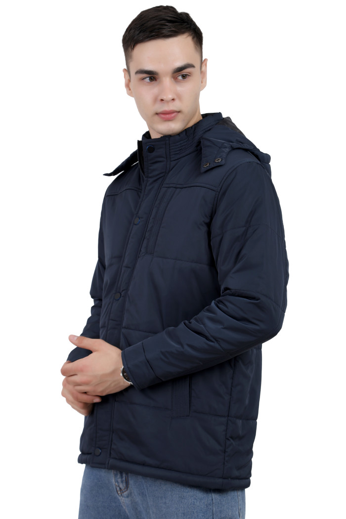 A left pose of a man wearing a Navy quilted jacket with a high neck collar, hood , zipper closure and pocket in hand designed for casual winter layering and comfort.