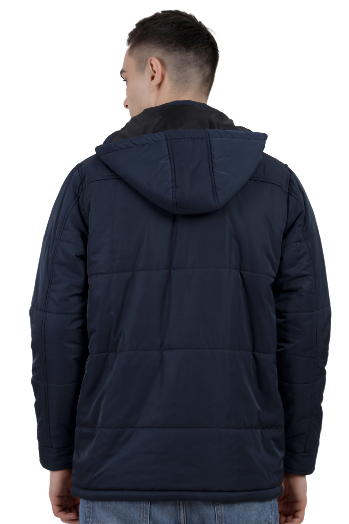 A back pose of a Mustard wearing a Navy quilted jacket with a high neck collar, hood , zipper closure and pocket in hand designed for casual winter layering and comfort.