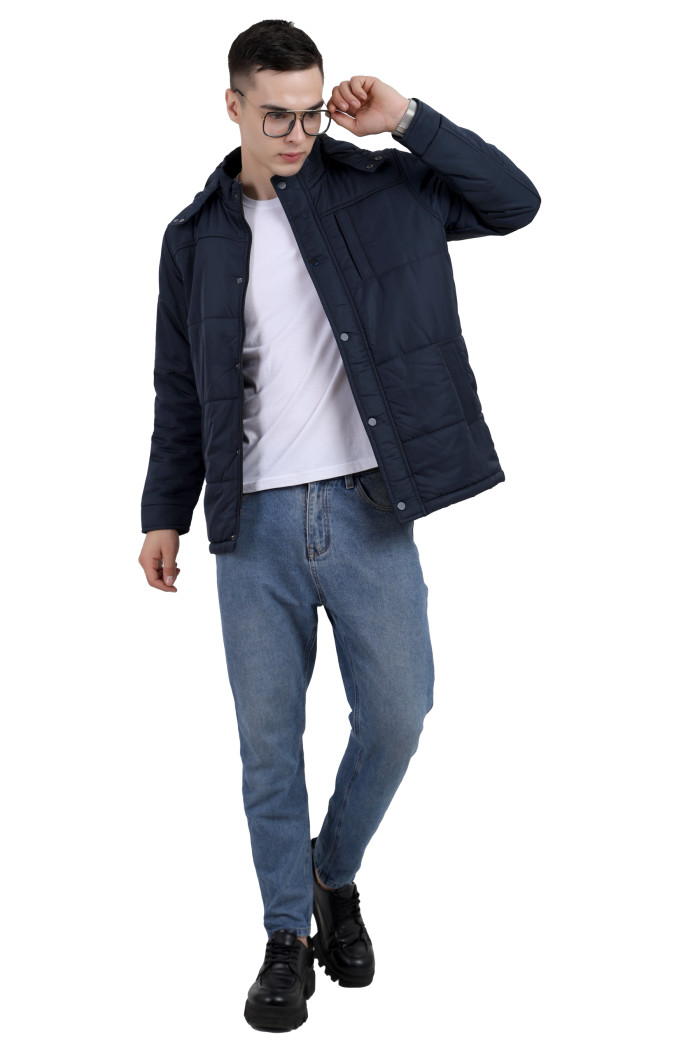 A tilted pose of a Mustard wearing a Navy quilted jacket with a high neck collar, hood , zipper closure and pocket in hand designed for casual winter layering and comfort.