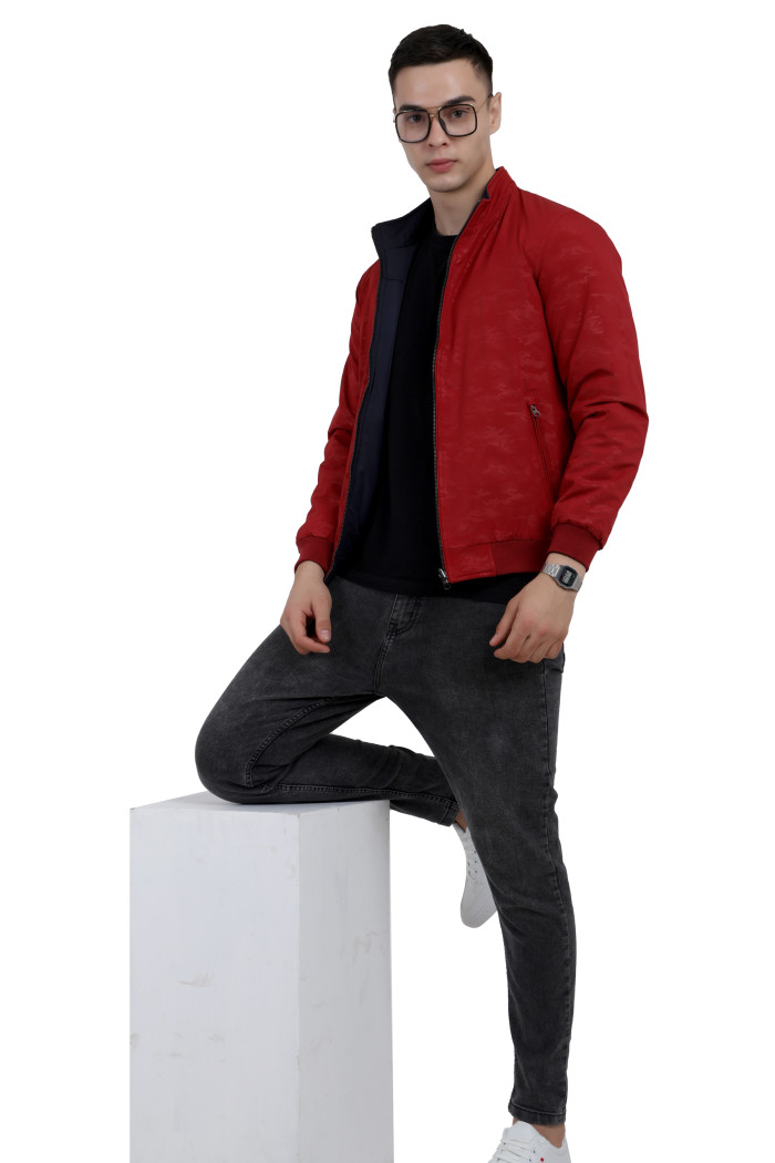 A tilted pose of a man wearing a Red- Navy Reversible jacket with a high neck collar, zipper closure and pocket in hand designed for casual winter layering and comfort