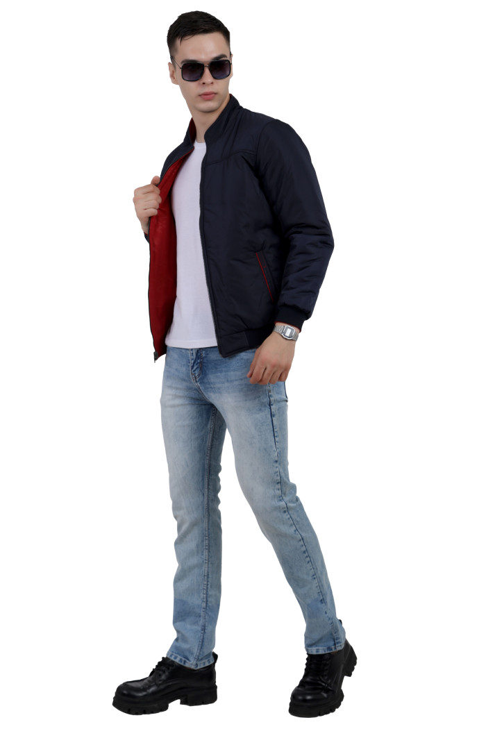 A tilted pose of a man wearing a Navy-Red Reversible jacket with a high neck collar, zipper closure and pocket in hand designed for casual winter layering and comfort