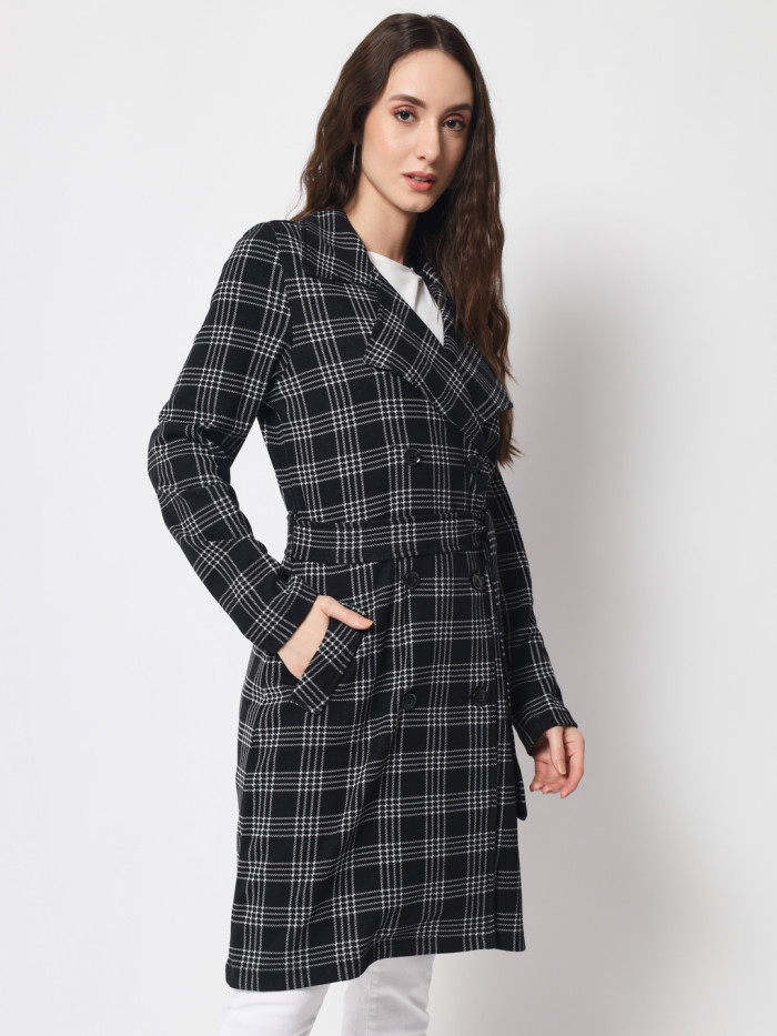 A left pose of a woman wearing a Black Checkered Long Coat with a lapel collar, belt, button closure and pocket in hand designed for casual and formal winter layering and comfort.