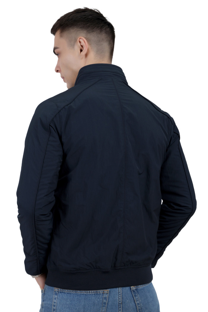 A back pose of a man wearing a Navy riding jacket with a high collar neck, zipper closure and pocket in hand designed for casual winter layering and comfort.