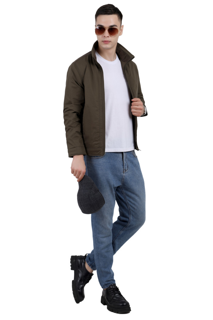 A tilted pose of a man wearing an Olive cotton jacket with a collar neck, zipper closure and pocket in hand designed for casual winter layering and comfort.