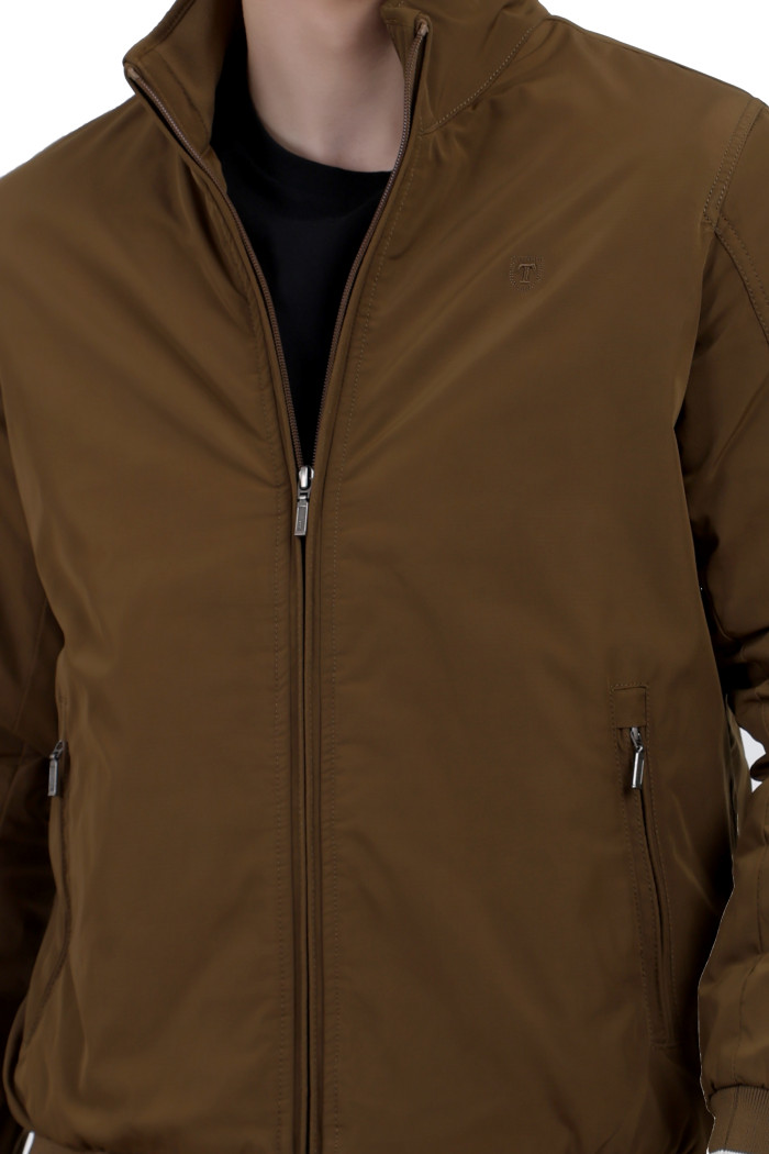 A cropped image of a man wearing a Khaki polyester jacket with a collar neck, zipper closure and pocket in hand designed for casual winter layering and comfort.