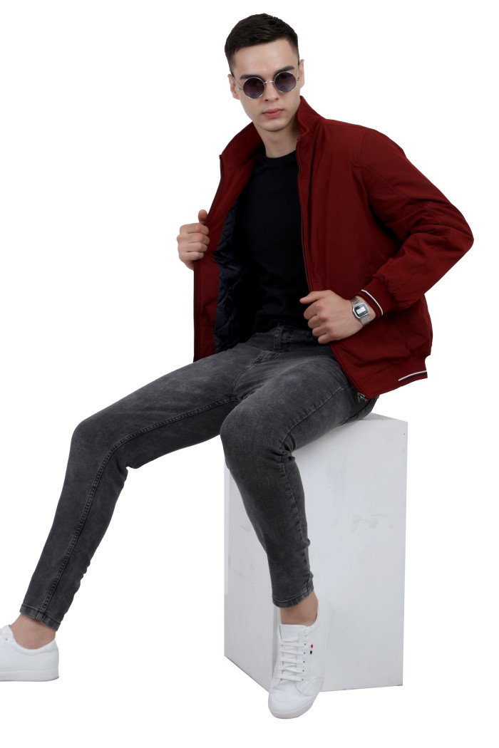 A tilted pose of a man wearing a Maroon polyester jacket with a collar neck, zipper closure and pocket in hand designed for casual winter layering and comfort.