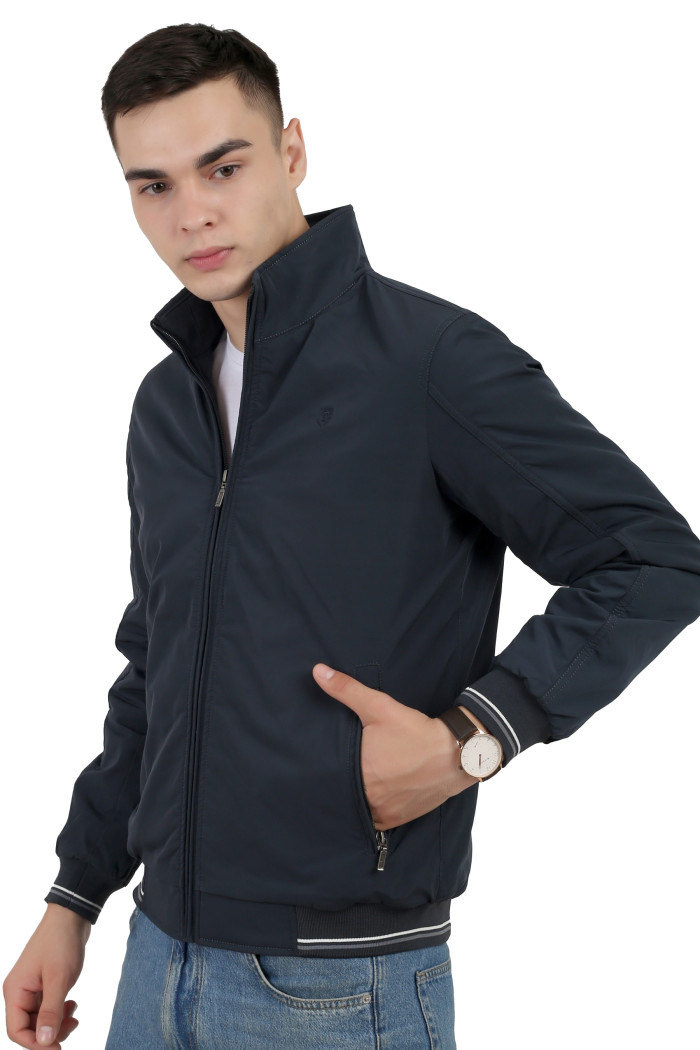 A right pose of a man wearing a Navy polyester jacket with a collar neck, zipper closure and pocket in hand designed for casual winter layering and comfort.