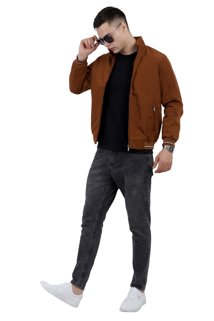 A tilted pose of a man wearing a Rust polyester jacketwith a collar neck, zipper closure and pocket in hand designed for casual winter layering and comfort.