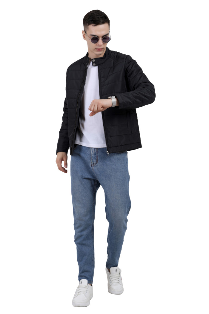 A tilted pose of a man wearing a black quilted biker Jacket with mock collar, zipper closure and pocket in hand designed for casual winter layering and comfort.