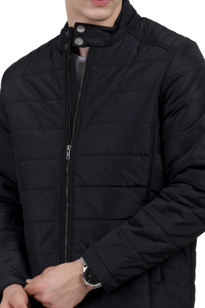 A cropped image of a man wearing a black quilted biker Jacket with mock collar, zipper closure and pocket in hand designed for casual winter layering and comfort.