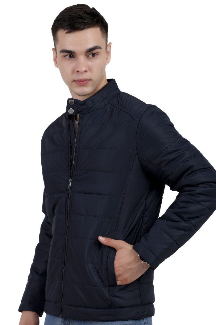 A left pose of a man wearing a navy quilted biker Jacket with mock collar, zipper closure and pocket in hand designed for casual winter layering and comfort.