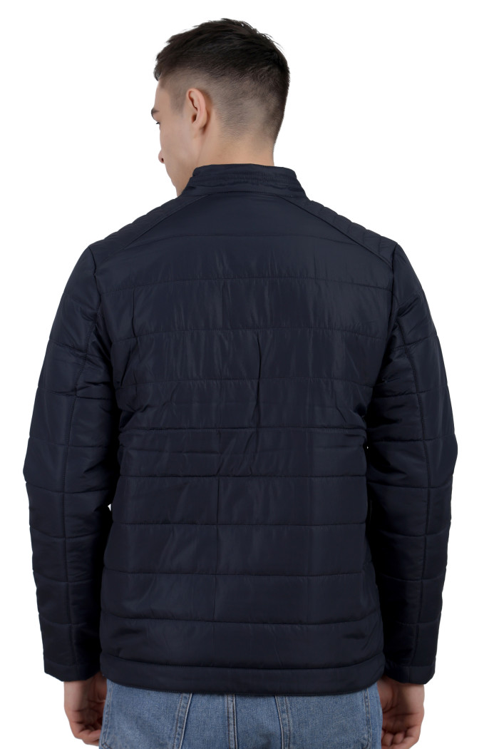 A back pose of a man wearing a navy quilted biker Jacket with mock collar, zipper closure and pocket in hand designed for casual winter layering and comfort.