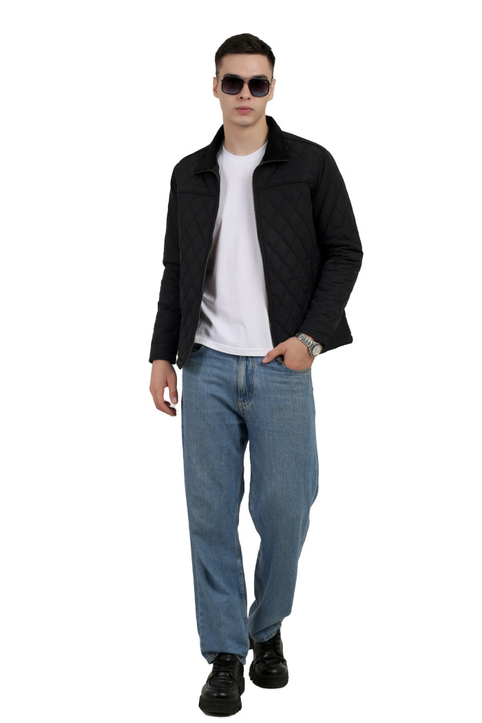 A tilted pose of a man wearing a Black quilted jacket t with a collar neck, zipper closure and pocket in hand designed for casual winter layering and comfort.