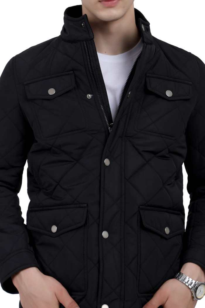 A cropped image of a man wearing a Black quilted jacket with a collar neck, zipper closure and pocket in hand designed for casual winter layering and comfort.