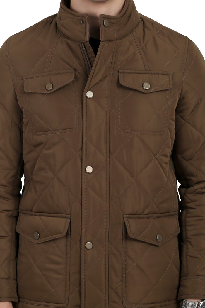 A cropped image of a man wearing a Bronze quilted jacket with a collar neck, zipper closure and pocket in hand designed for casual winter layering and comfort.