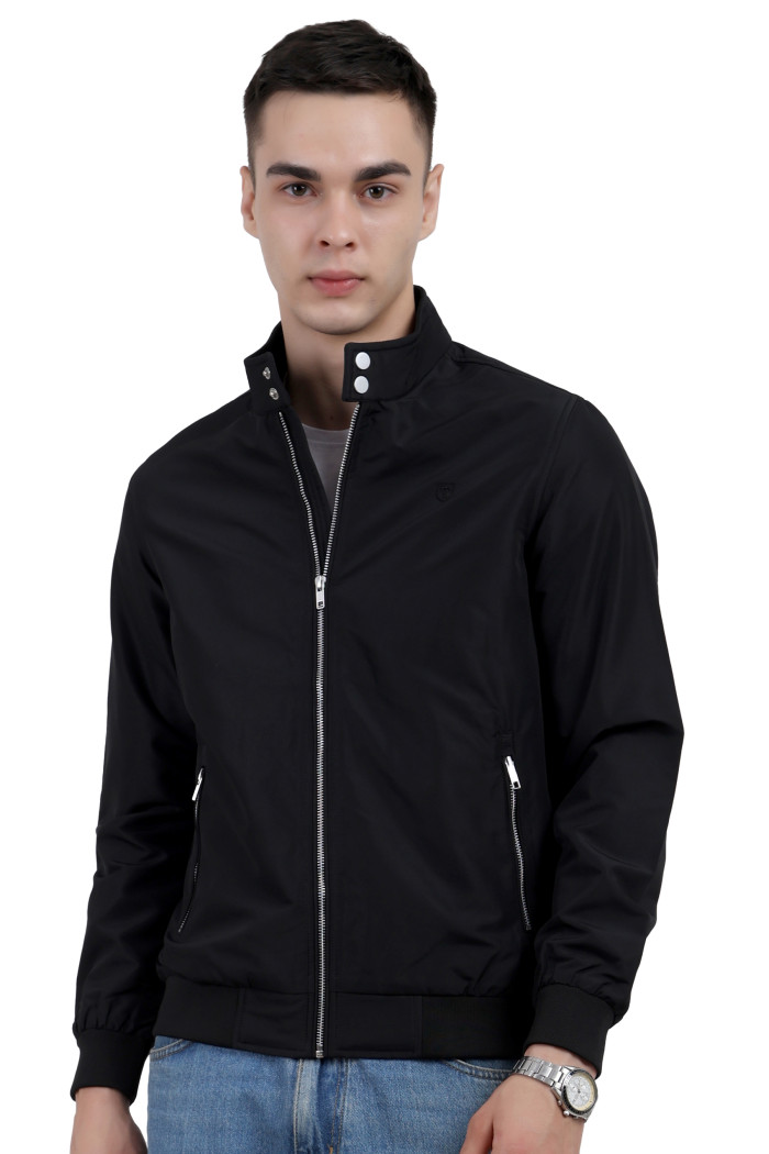 A man wearing a Black Matt Finish Lightweight Jacket with high neck collar, zipper closure and pocket in hand designed for casual winter layering and comfort.