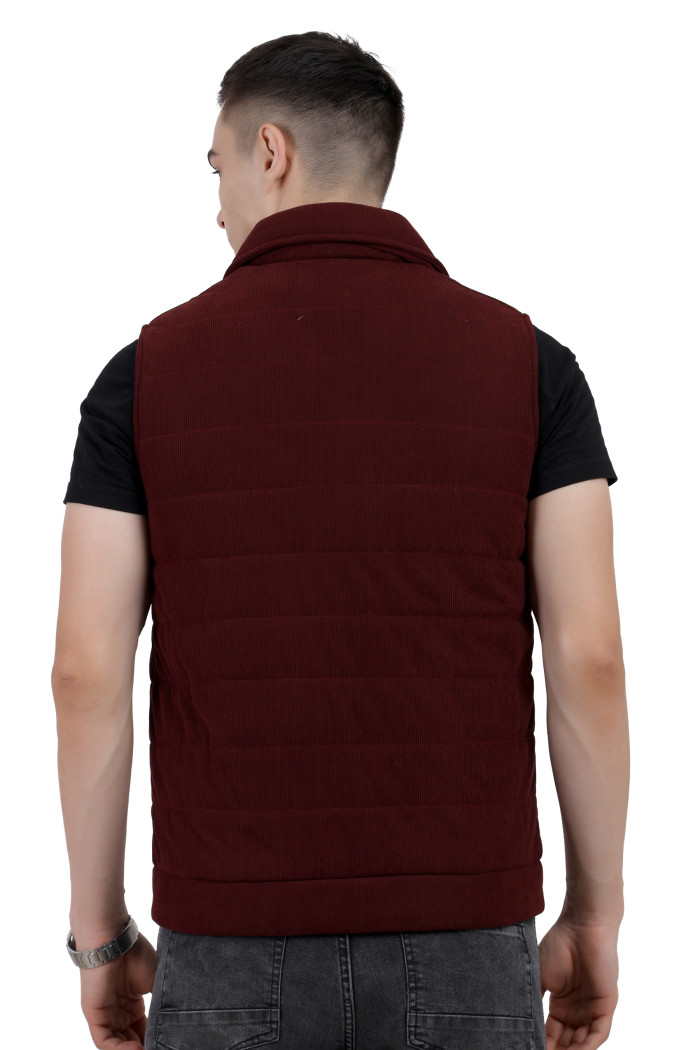 A back pose of a man wearing a Maroon half jacket with a high neck ,zipper closure and pocket designed for casual winter layering and comfort.