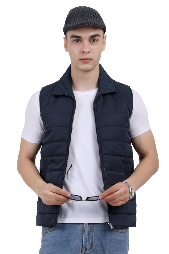 A man wearing a navy half jacket with a high neck, zipper closure and pocket in hand designed for casual winter layering and comfort.