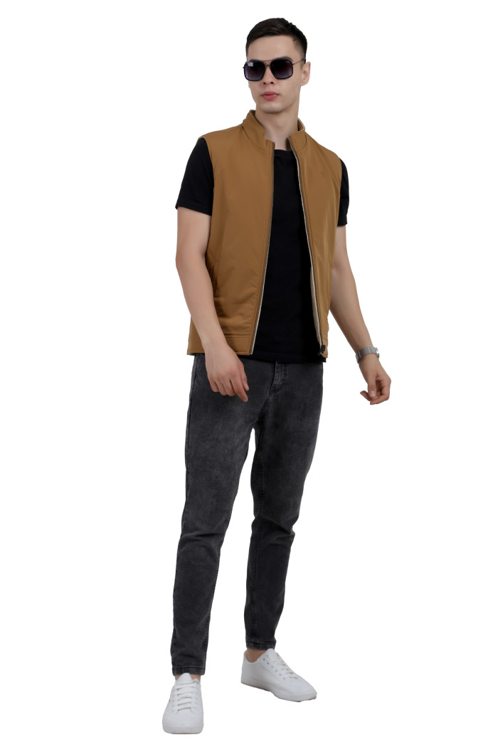 :A tilted pose of a man wearing a Khaki half jacket with a high neck, zipper closure and pocket in hand designed for casual winter layering and comfort.