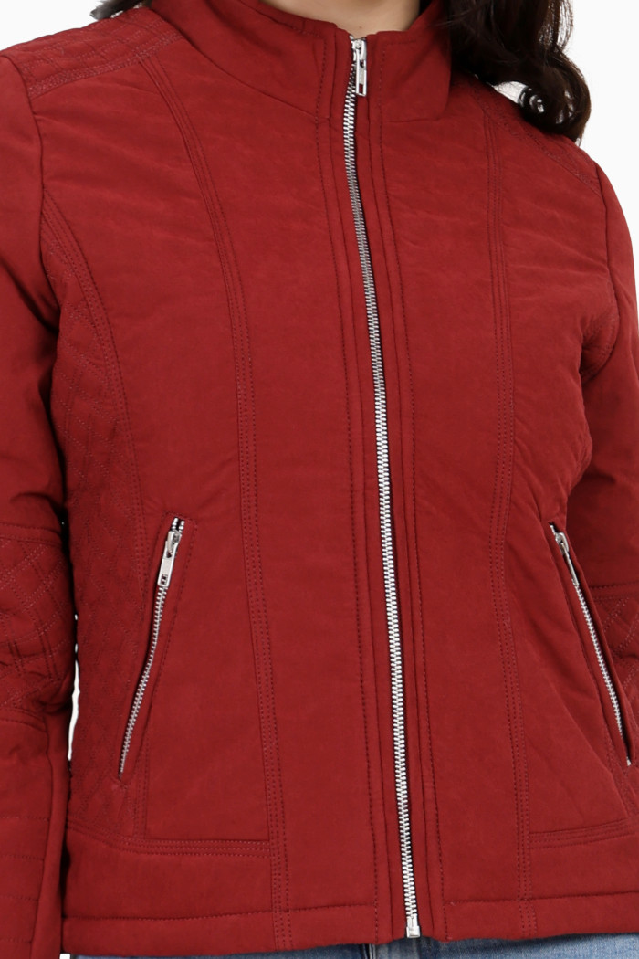 A cropped image of a woman wearing Trufit’s maroon quilted biker jacket with a Chinese collar, sliver zip closure and side pockets with a silver zipper.