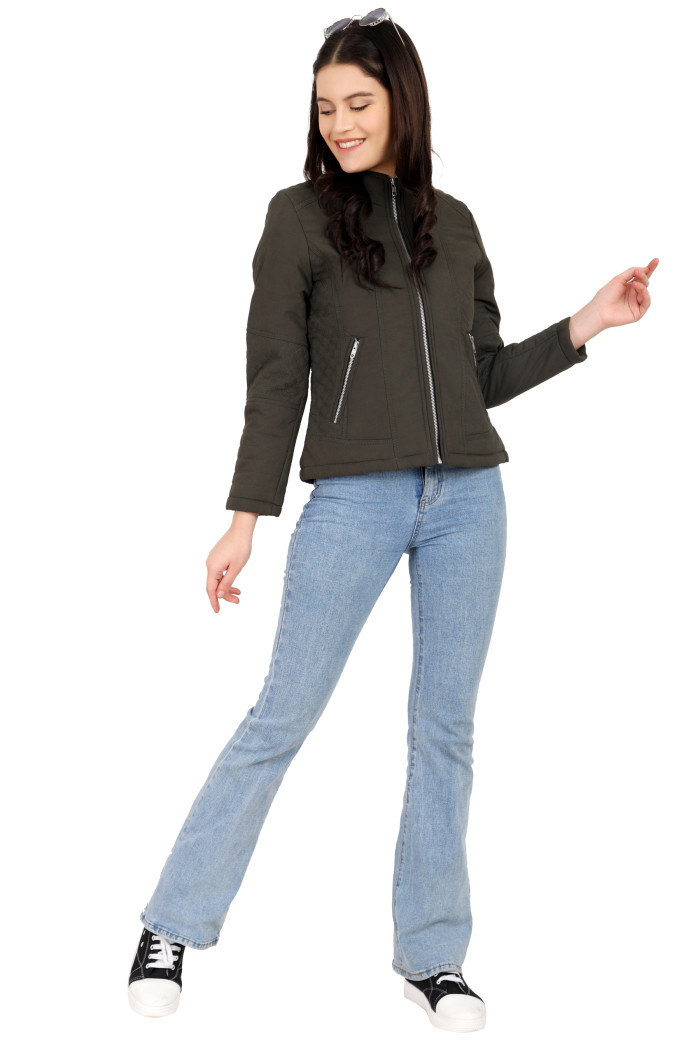 A woman in a standing pose, wearing Trufit’s olive quilted biker jacket with a Chinese collar, sliver zip closure, and side pockets with a silver zipper and blue jeans.