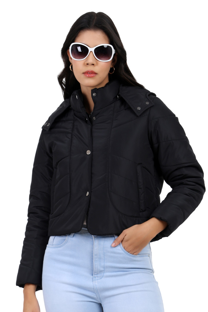 A woman in a standing side pose, wearing Trufit’s black quilted jacket with a high neck collar, zip closure, side pockets and blue jeans with her hands in the pocket.