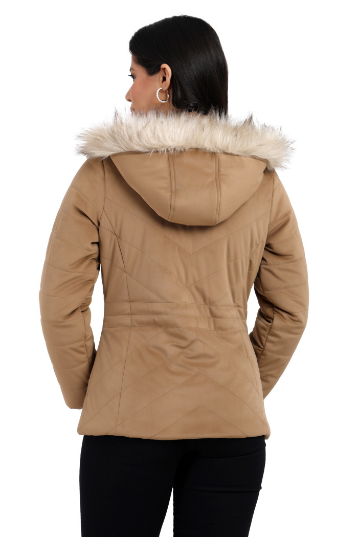 A back pose of a standing woman, wearing Coatsnmore’s coffee velvet quilted jacket with a removable hood and blue jeans.