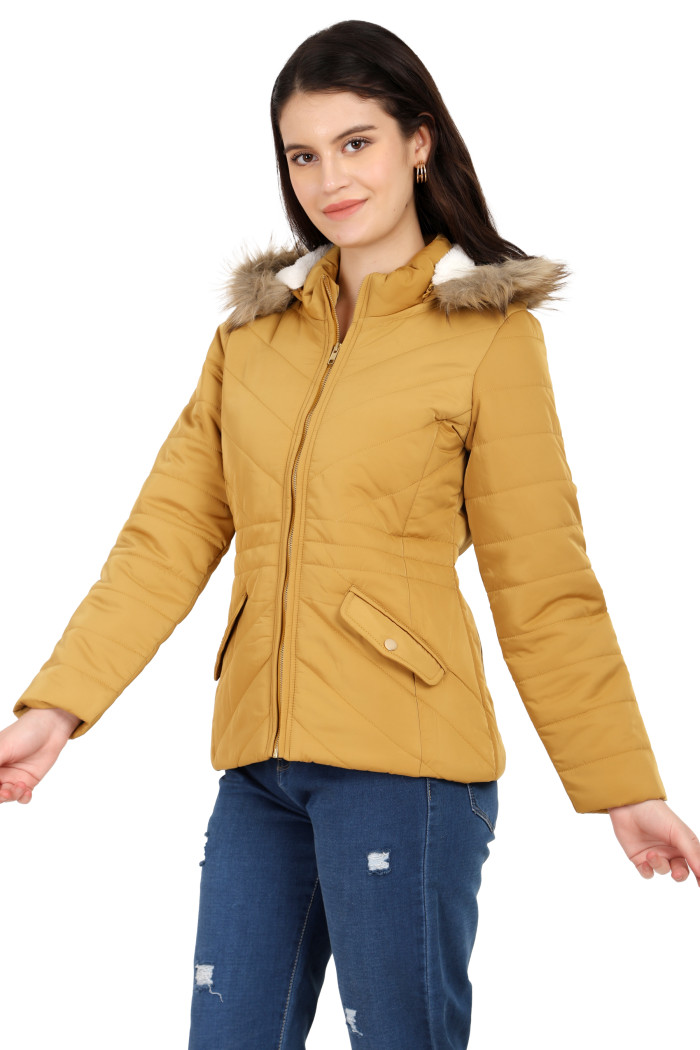 A standing pose of a woman wearing Coatsnmore’s casual jacket in mustard colour with a textured pattern, slash placket pockets, a zip closure, a detachable hood and blue jeans.