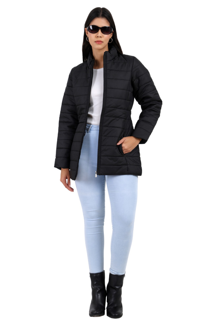 A woman in a standing pose in black shades is wearing Trufit’s black quilted jacket with a mandarin collar, zip closure, side pockets with concealed zippers, and blue jeans, and her left hand is in the pocket.