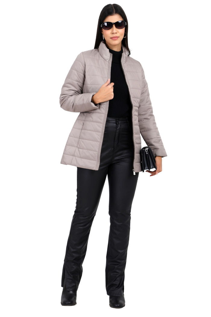 A woman in a standing pose in black shades, wearing Trufit’s stone quilted jacket with a mandarin collar, zip closure, and side pockets with concealed zipper and black jeans, holding a clutch with her left hand and jacket with her right hand.