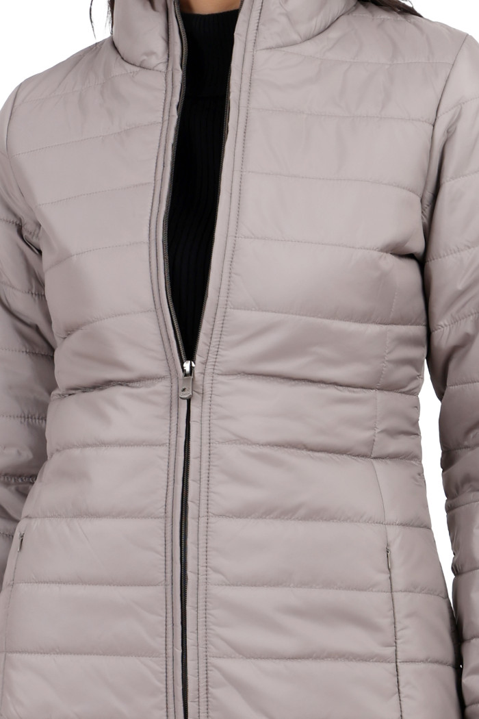 A cropped image of a woman wearing Trufit’s stone quilted jacket with a high neck collar, zip closure and side pockets with concealed zippers.