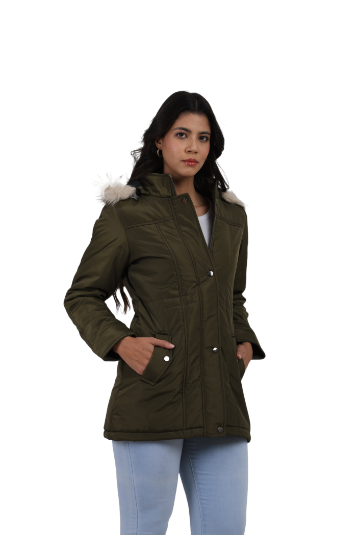 A woman is giving a standing pose, wearing Coatsnmore’s rust quilted parka jacket with a detachable hood, zip closure, button placket, side pockets and quilted pattern and blue jeans with both hands in pocket.