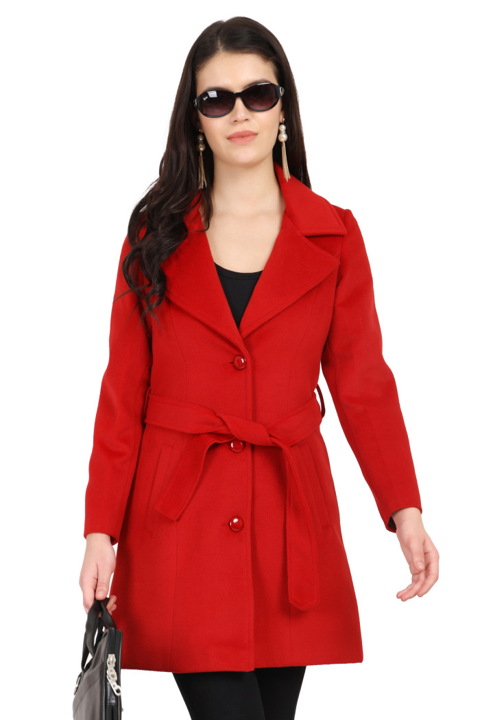 A standing woman wearing black shades is dressed in Coatsnmore’s long red tweed coat with a belt featuring a lapel collar, button-up design and side pockets styled with black tights while holding a bag from her right hand.