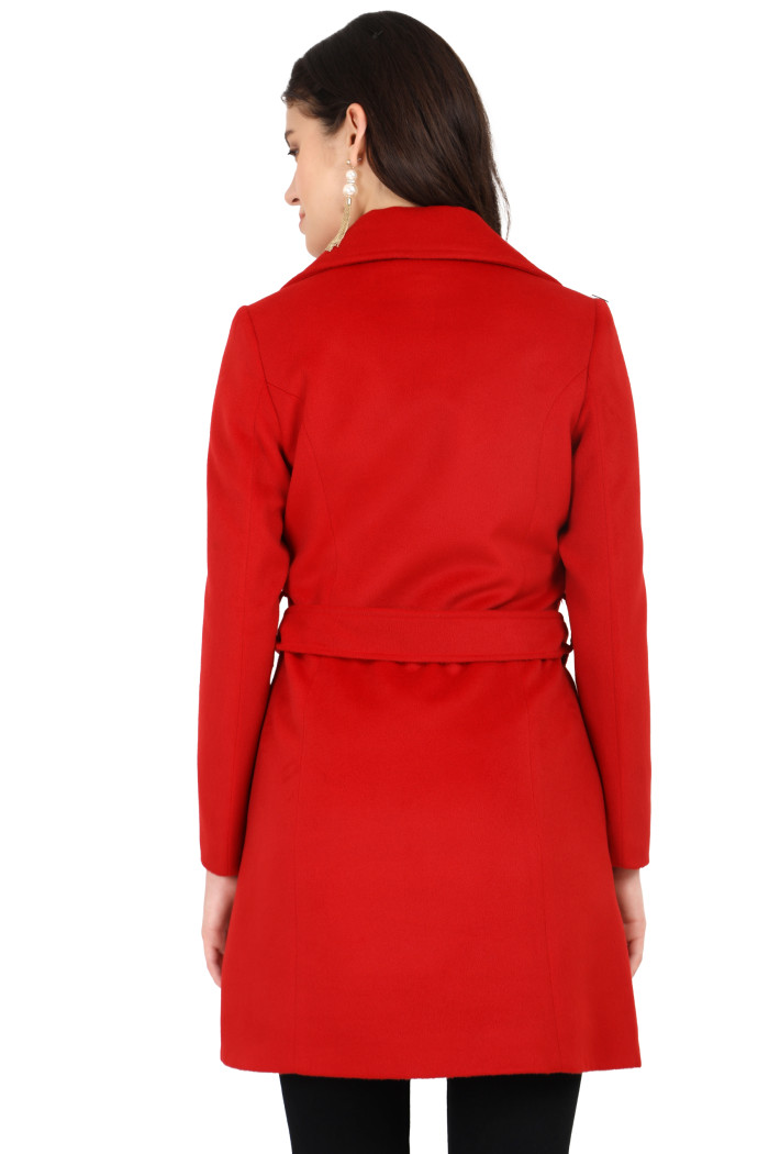 The back pose of a standing woman wearing the tailored fit Coatsnmore’s long red tweed coat with a belt featuring a lapel collar, button-up design and side pockets and styled with black tights.