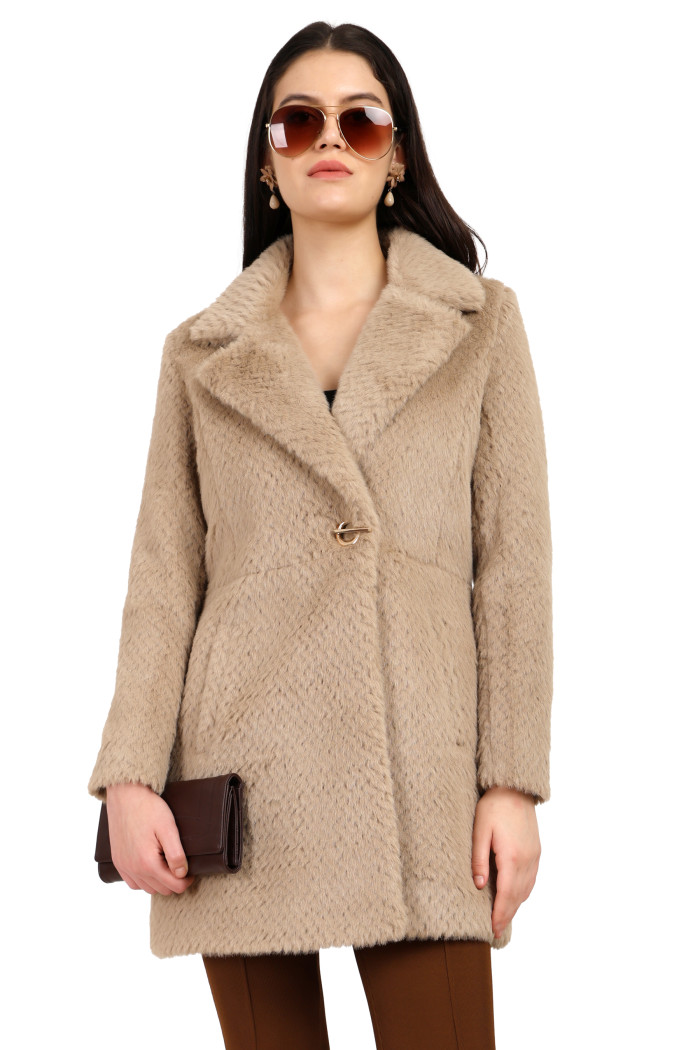 A woman in a standing side pose, wearing Coatsnmore’s pearl double-breasted Semi-Long coat with a lapel collar, button closure, side pockets, and brown tights, holding a clutch from her right hand.