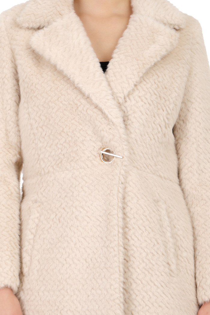 A woman in a cropped image is wearing Coatsnmore’s pearl double-breast Semi-Long coat with a lapel collar, button closure and side pockets.