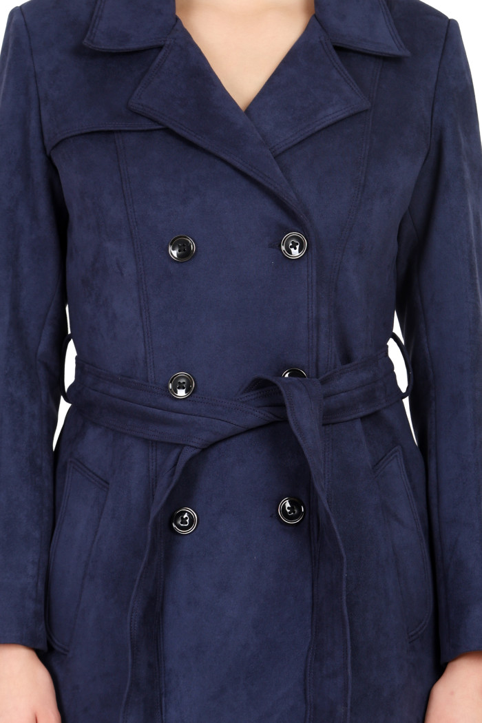 A woman in a cropped image is wearing Coatsnmore’s navy double-breast trench coat with a lapel collar, button closure, belt and side pockets.